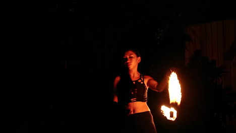 Junge-Dame,-Die-Eine-Feuershow-Oder-Eine-Thumbuakar-performance-In-Der-Nachtsafari,-Singapur,-Durchführt