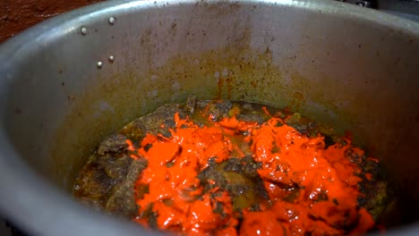 Cooking-and-Garnishing-bubbling-Indian-Chicken-curry-with-chilies-and-spices