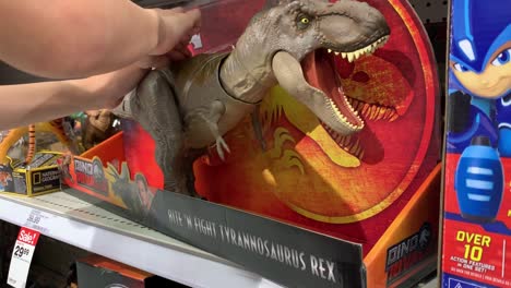 Close-up-of-a-small-hand-playing-with-a-newly-released-T-Rex-action-figure-toy-from-the-movie-"Jurassic-World-Fallen-Kingdom"