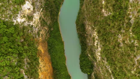 Spiraling-top-down-view-of-the-gorgeous-turquoise-green-Nho-que-river-to-reveal-lush-green-mountain-slopes-in-norther-Vietnam