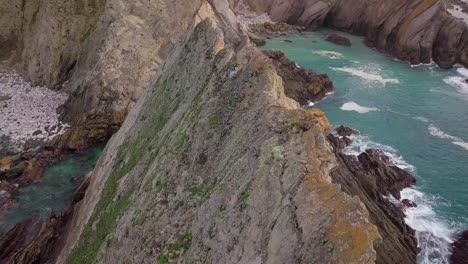 Drone-flying-towards-cliffs-over-geological-spikes-on-the-California-Coast-on-the-Pacific-ocean