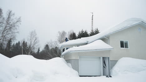 Mann-Schiebt-Nach-Einem-Sturm-Schnee-Vom-Hausdach