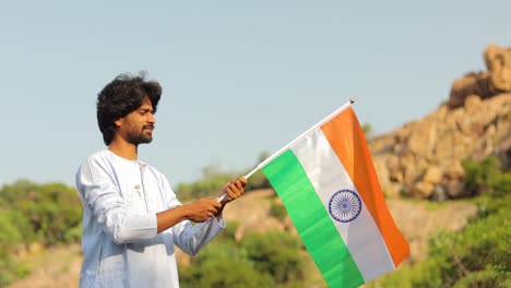 Der-Junge-Mann-Mit-Traditioneller-Indischer-Kleidung,-Die-An-Einem-Sonnigen-Tag-Die-Indische-Flagge-Hält