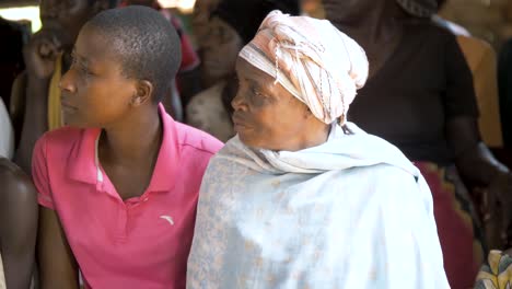 ältere-Afrikanische-Frauen-Mit-Kopftuch,-Die-In-Einem-Gemeinschaftszentrum-In-Uganda-In-Die-Kamera-Blicken