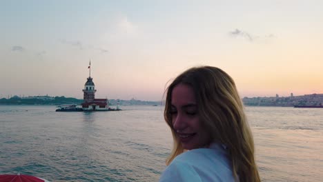 Zeitlupe:-Schönes-Mädchen-Genießt-Sonnenuntergangblick-Auf-Den-Bosporus-Mit-Blick-Auf-Den-Jungfernturm-Im-Hintergrund-In-Istanbul
