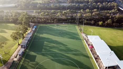Spiral-up-from-right-to-left-drone-footage-over-men's-premier-league-field-hockey-match-at-Elgar-Park