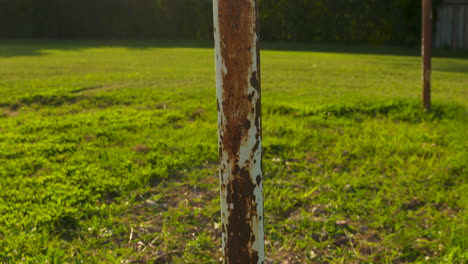 Pan-up-along-the-rusted-poles-of-an-old-soccer-goalpost