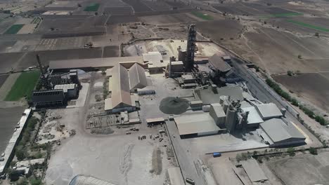 Aerial-view-of-a-small-plant-for-the-production-and-cleaning-rubble-and-cement-near-the-heaps-of-building-materials-from-the-pipe-of-which-gray-smoke-goes