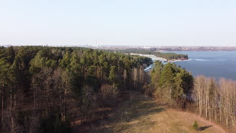 Drone-ascend-view-and-reveal-of-Kaunas-lagoon-and-city-in-background
