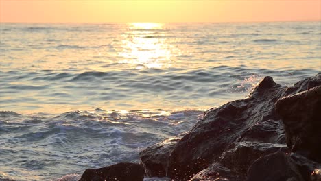 Wellen,-Die-Bei-Sonnenuntergang-In-Den-Felsen-Eines-Felsigen-Strandes-Brechen