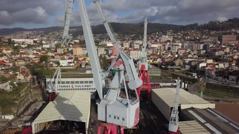 Aerial-travelling-of-the-big-grey-cranes-of-the-shipyard-factory-Vulcano-in-Vigo,-Spain