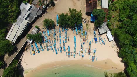 Jukung,-wooden-fishing-boats-on-sand-aerial-close-up,-Gesing-Beach,-Yogyakarta
