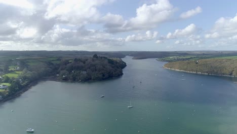 Aerial-approach-towards-land-from-the-water-at-Helford-in-Cornwall,-UK