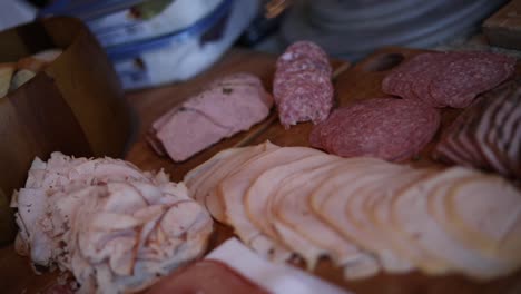Shot-slowly-panning-over-a-platter-of-different-variety-of-meats-including-turkey,-ham,-and-salami