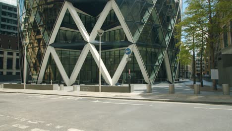 Cinematic-slow-motion-pan-of-30-St-Mary-Axe-skyscraper-courtyard-and-London-streets-in-summer-sunshine