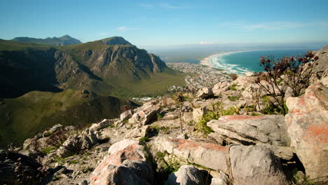 Tilt-up-shot-from-top-of-mountain-of-pristine-beach-along-coastline,-Hermanus,-South-Africa