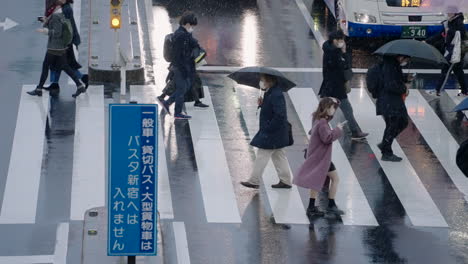 Japanese-People-Wearing-Masks,-Crossing-The-Road-During-Coronavirus-Pandemic-In-Tokyo,-Japan