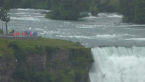 Group-of-people-admires-the-power-of-massive-waterfall-in-safe-zone