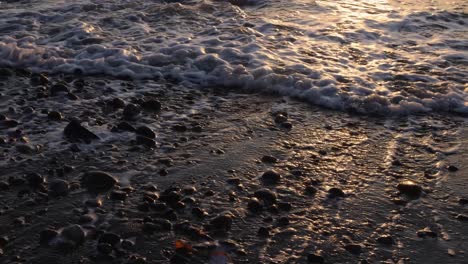 closeup-of-lots-of-pebbles-and-rocks-on-the-beach-with-waves-coming-in