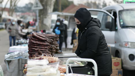 Street-Vendor-With-Facemask-On-Sells-Chorizo-At-The-Market-In-Leiria-City