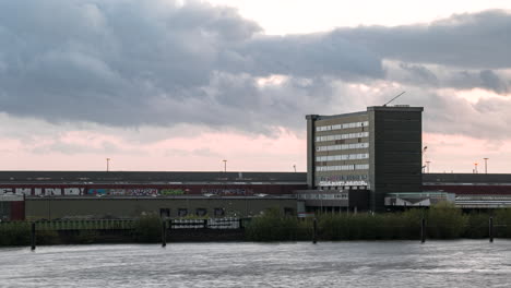 Time-lapse-shot-of-river-Elbe-in-motion-and-Elbbruecken-and-old-warehouse-of-Hamburg-during-flying-clouds-at-sky