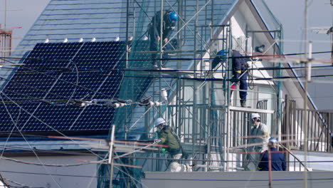 Arbeiter---Bauarbeiter-Auf-Gerüsten,-Die-Während-Einer-Pandemie-In-Tokio,-Japan,-Auf-Dem-Dach-Des-Gebäudes-Arbeiten