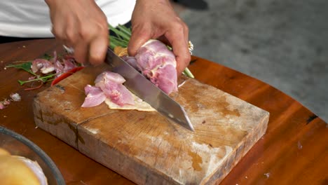 Chef-Cortando-Ala-De-Pollo-En-Una-Mesa-De-Madera-Para-Sopa-Tom-Kha-Kai