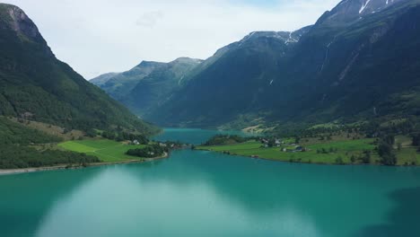 Amazing-panoramic-view-of-Oldevatnet-glacial-lake-surrounded-by-tall-mountains---Norway-aerial