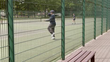 Slow-motion-man-practice-tennis-on-court-suburban-public-playground