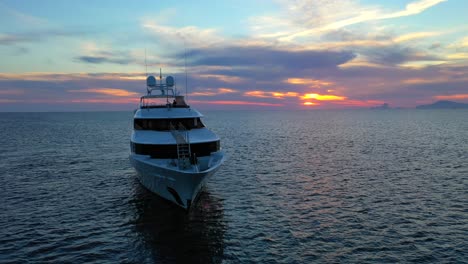 Luxury-mega-yacht-sunset-sea-view-sailing-in-Ibiza,-beautiful-Mediterranian-sea,-jetset-elite-lifestyle,-4K-drone-shot