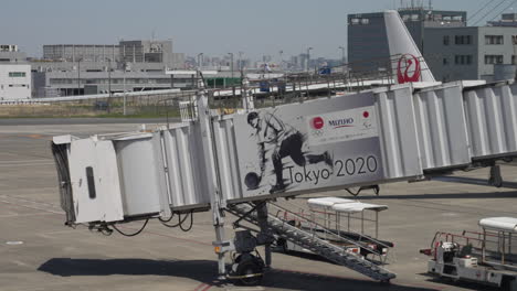 Anuncio-Olímpico-De-Tokio-2020-En-Un-Puente-De-Chorro-Con-Escalera-Y-Vehículos-Aéreos-En-El-Aeropuerto-De-Haneda-En-Tokio,-Japón