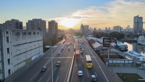 Aerial-of-trafficked-highway-and-skyline-of-Buenos-Aires-at-sunset