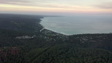 Aerial-slowly-descends-toward-the-Anglesea,-Australia-coast-at-dusk
