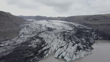 Aerial-drone-view-towards-the-Solheimajokull-Glacier,-in-gloomy,-overcast-Iceland