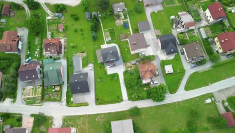 Fliegen-über-Gassen-Von-Einfamilienhäusern-Siedlung-Zwischen-Grünen-Rasenflächen