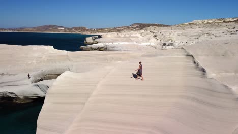Mujer-Turista-Explorando-La-Playa-De-Sarakiniko,-Isla-De-Milos,-Grecia