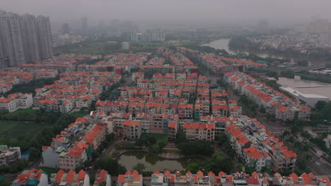 Foggy,smoggy-early-morning-drone-footage-over-urban-high-rise-and-villa-housing-developments-in-district-seven-Saigon,-Ho-Chi-Minh-City,-Vietnam