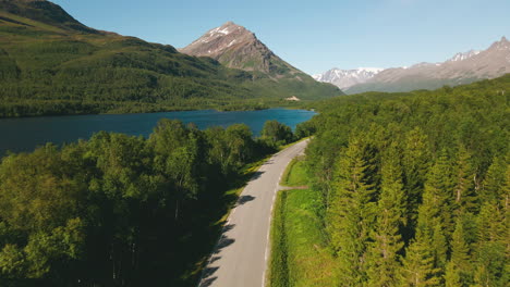 Carretera-Costera-Entre-El-Follaje-De-Los-árboles-Con-Montañas-Forestales-Y-Alpinos-Cerca-De-Tromso-En-El-Norte-De-Noruega