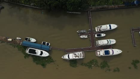 Top-down-drone-shot-over-river-marina-with-luxury-power-boats