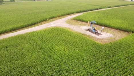Aerial-View-Of-An-OIl-Pumpjack-At-The-Corn-Field-In-Isabella-County,-Mount-Pleasant-Michigan