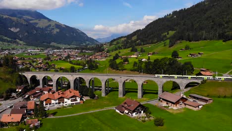 Aerial:-regional-train-crossing-the-stone-viaduct-of-Frutigen-in-the-Alps