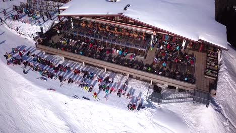 Aerial-drone-video-of-crowded-ski-restaurant-with-terrace-full-of-people