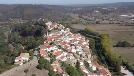 Aerial-drone-flight-towards-the-hills-with-view-of-a-few-villas-in-Aljezur,-Algarve,-Portugal