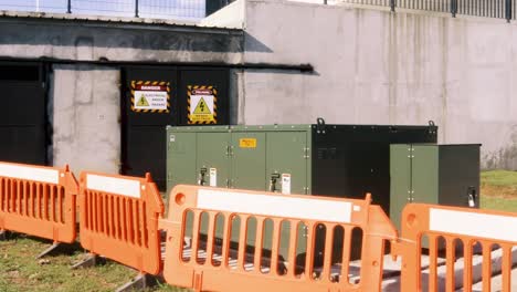 A-pan-shot-of-a-high-voltage-electricity-substation-and-backup-generator-at-the-Amador-Convention-center,-warning-signs-and-orange-barriers-highlighting-the-potential-danger-of-the-area,-Panama-City