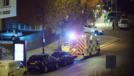 London-ambulance-with-flashing-lights-parked-on-a-street-at-night