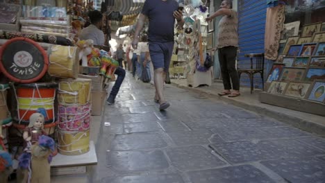 Tienda-De-La-Esquina-Que-Muestra-Productos-Locales-Y-Turistas-Gente-Comprando-Caminando-Por-El-Mercado-Público-En-Túnez