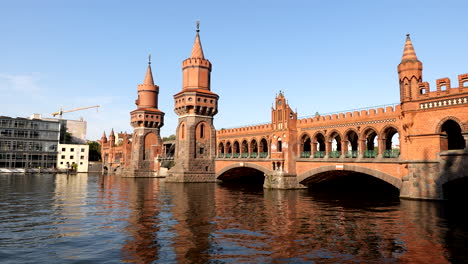Puente-Oberbaum-Sobre-El-Río-Spree-Al-Atardecer-En-Berlín,-Alemania,-Arquitectura-De-Estilo-Gótico-De-Ladrillo-Del-Norte-De-Alemania,-Hito-De-La-Ciudad-Desde-1895