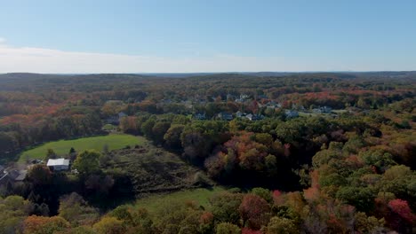 Buildings-of-Haverhill-town-and-endless-forestry-landscape-with-autumn-colors,-aerial-drone-view