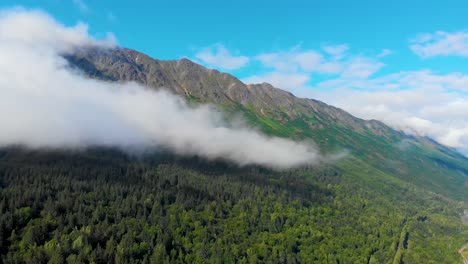 4K-Drone-Video-of-Low-Elevation-Clouds-Racing-Across-Steep-Grassy-Mountain-on-Shore-of-Turnagain-Arm,-Alaska-in-Summer