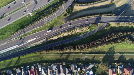 Smooth-tracking-aerial-perspective-shot-from-top-down-of-vehicles-entering-the-main-carriage-way-of-major-highway-interchange-below